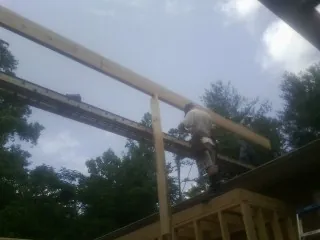 Carpenter setting a ridge beam over a new addition frame — Ice Dam Removal by Roofing Brothers in Stanford
